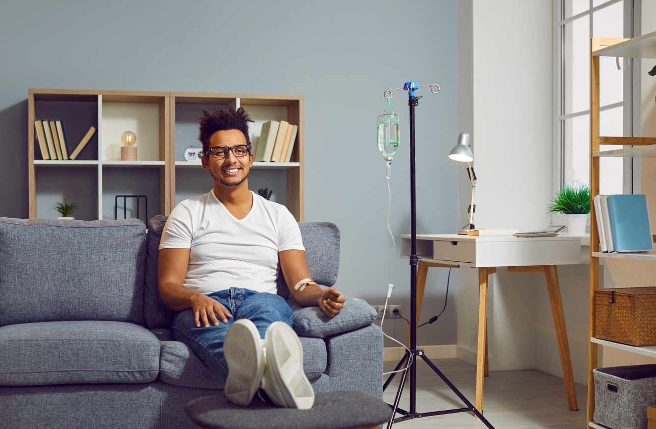 Young Happy African American Man Receiving IV Drip Infusion and Vitamin Therapy.